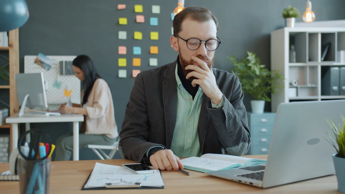 Business owner thinking through options at his laptop